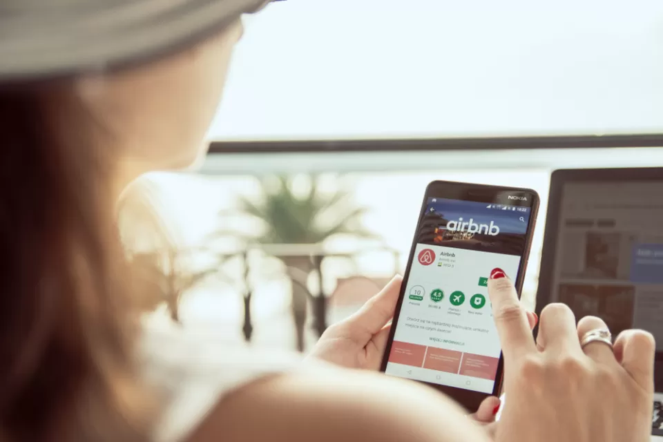 Woman searchinig Airbnb app on phone